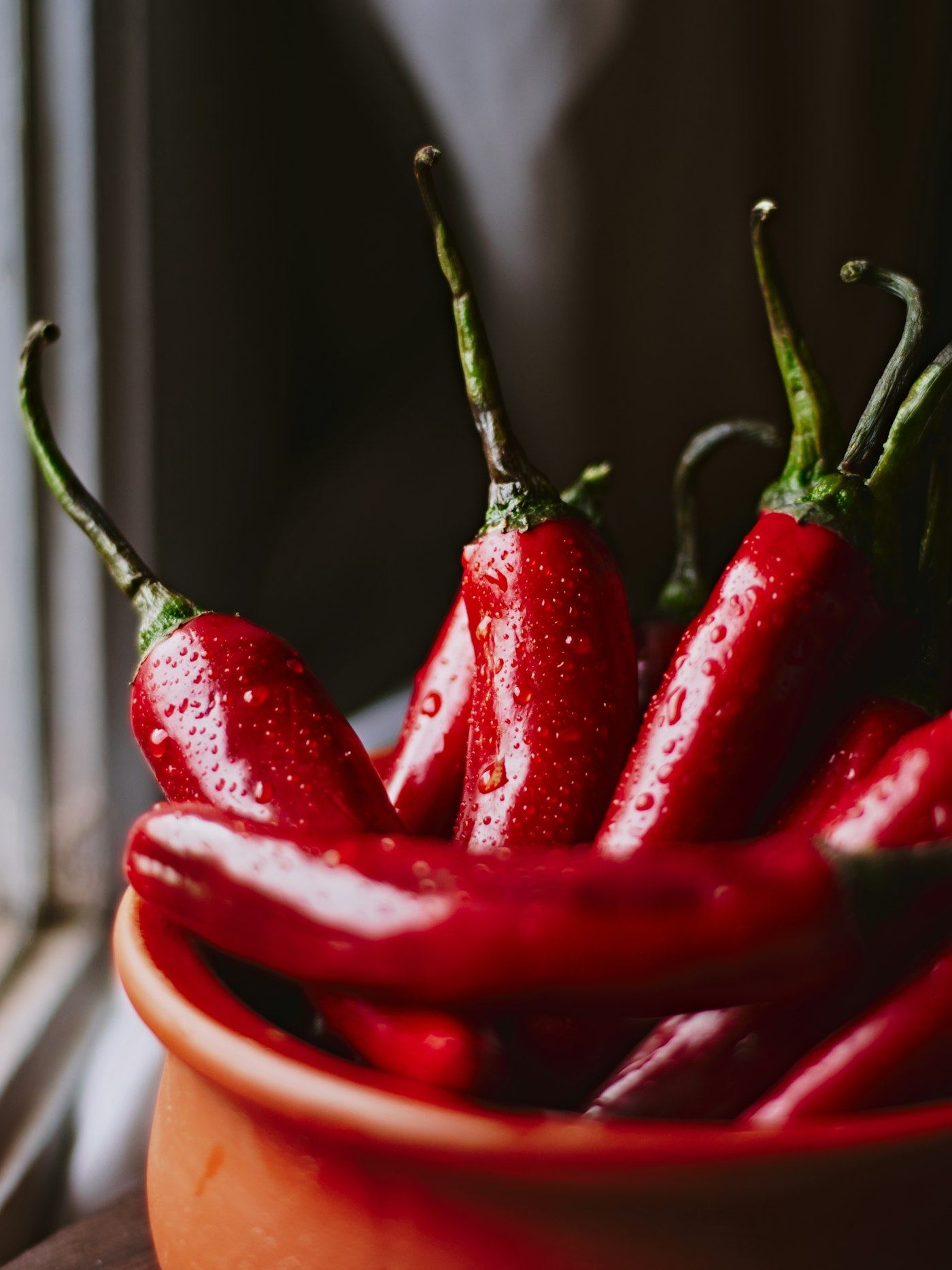 Fresh red chili peppers heaped in a terracotta bowl