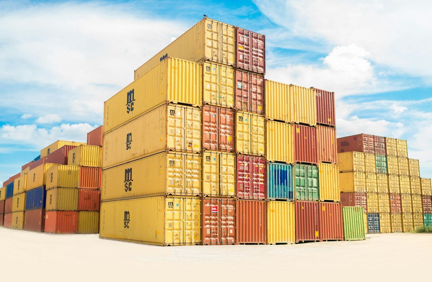 Stacked intermodal shipping containers in a sunlit cargo yard