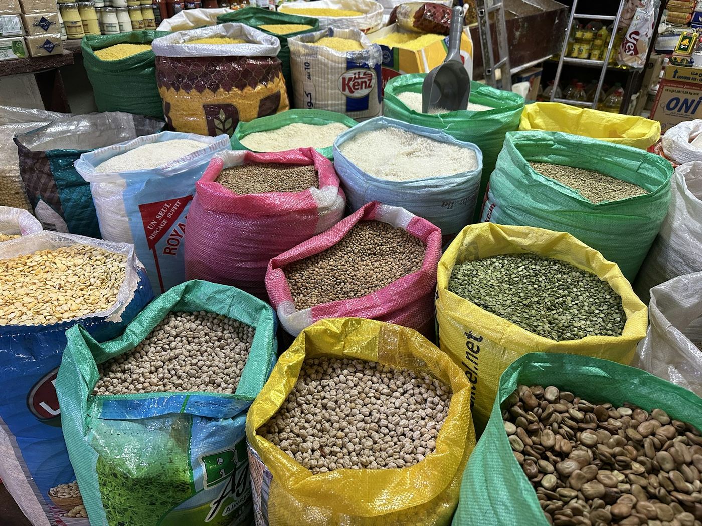 Open sacks of rice, lentils, chickpeas, and beans at a wholesale market
